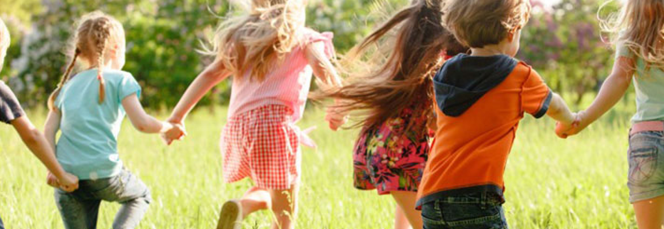 A group of children running in a field.